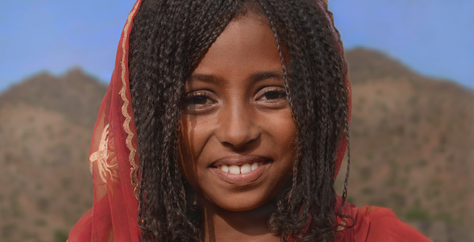 Afrikanisches Mädchen vor Wüstenlandschaft