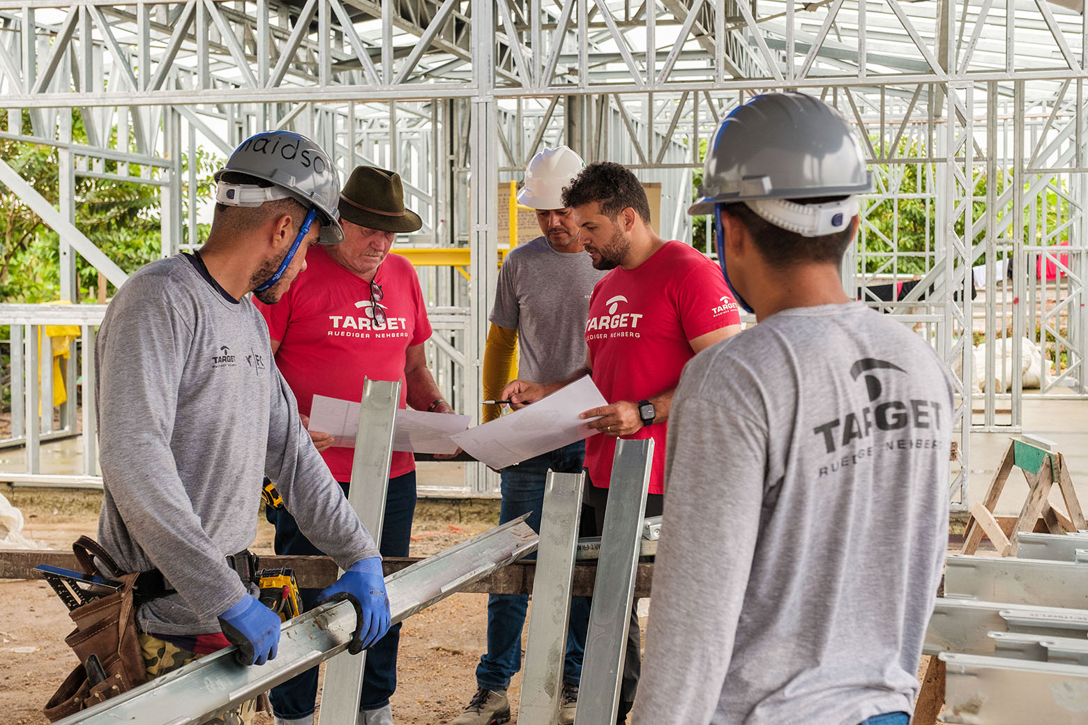 Die TARGET-Bauingenieure Hosti Jose und Brayan Reis besprechen den Aufbauplan mit Mitarbeitern auf dem Bau