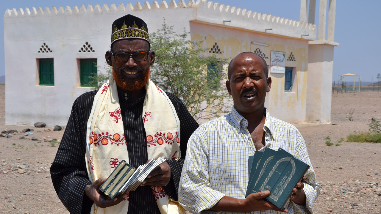 Freude eines Imam über das "Goldene Buch" mit unserem Mitarbeiter Abdoul.